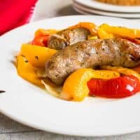 sausages, sliced peppers on white plate