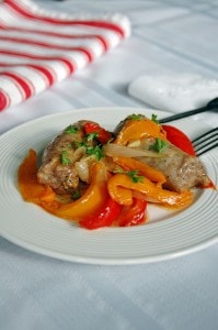 Sausage and Peppers on a plate with fork and knife