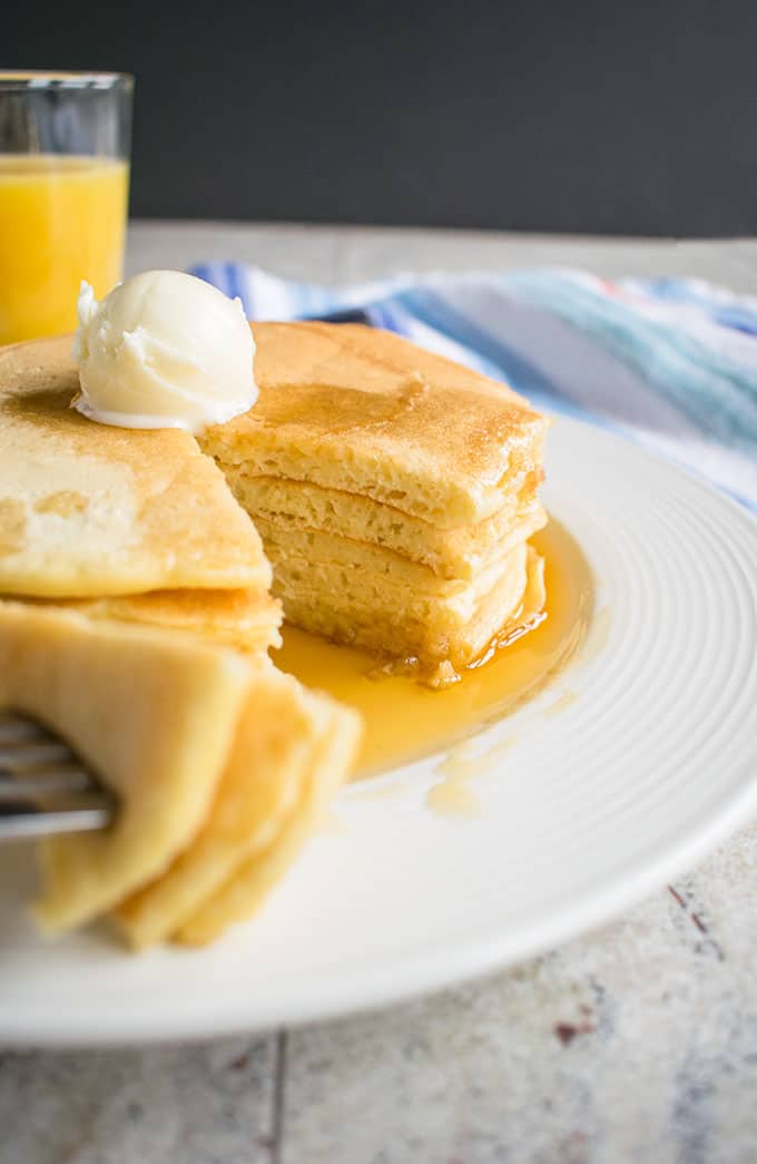 forkful of homemade pancakes being taken from a stack