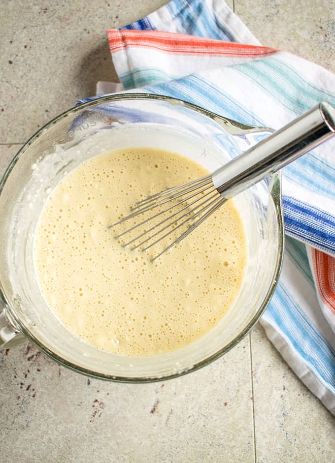 pancake batter in a mixing bowl with a whisk 