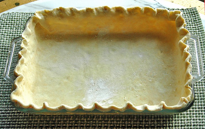 raw pie crust in rectangular glass pan