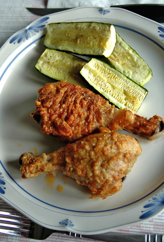 Parmesan Chicken Drumsticks with Garlic Butter and zucchini on a plate