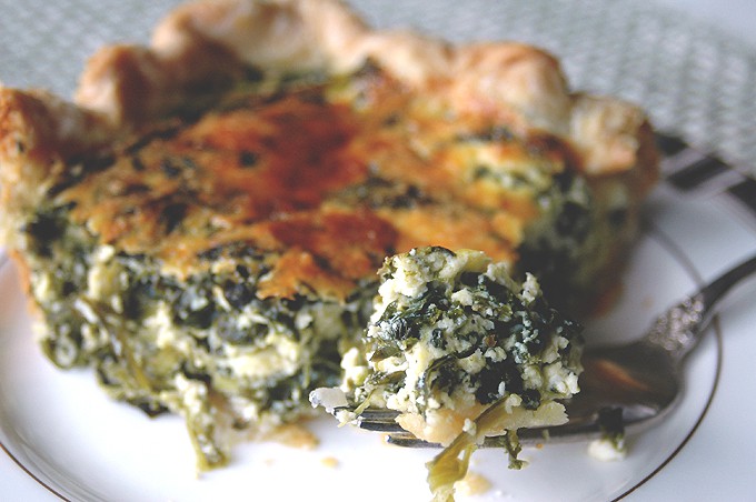 close-up of a forkful of pie with spinach and ricotta