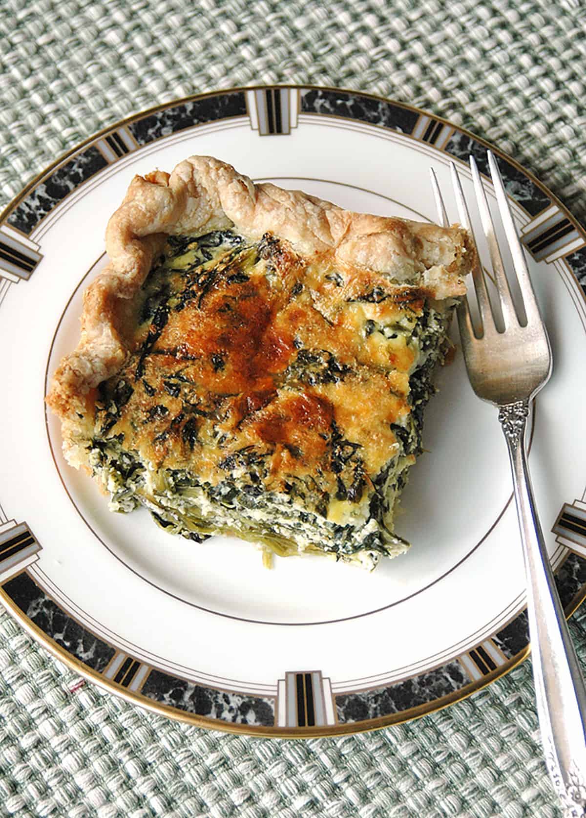 slice of spinach ricotta pie on a plate with fork