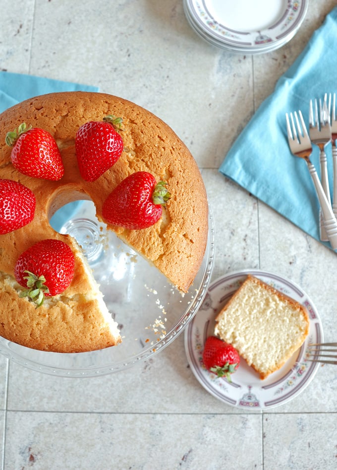 overhead view of pound cake on a cake stand, slice of cake on a plate