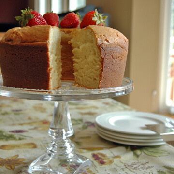 Pound cake with piece taken from it on a cake stand