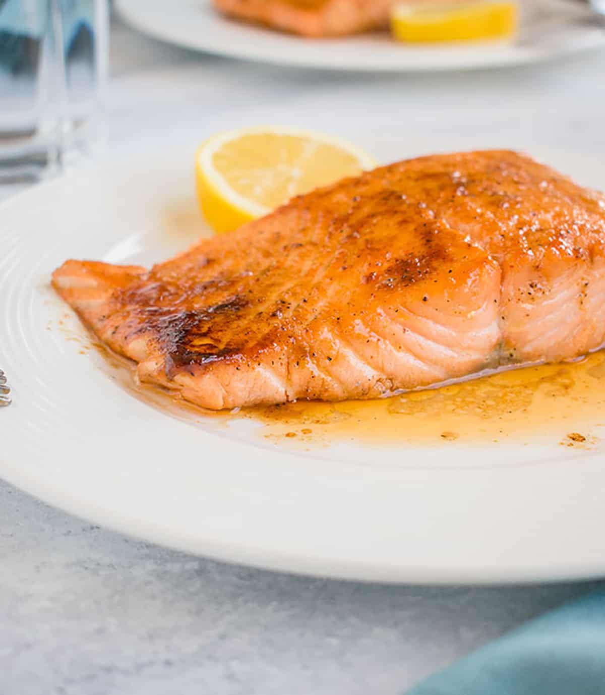 Photo of 10-Minute Maple-Glazed Salmon on plate with slice of lemon