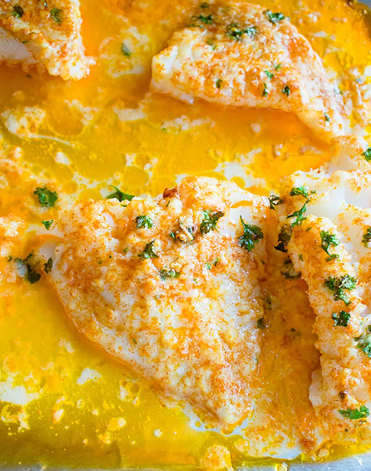 A close up view of baked cod with butter