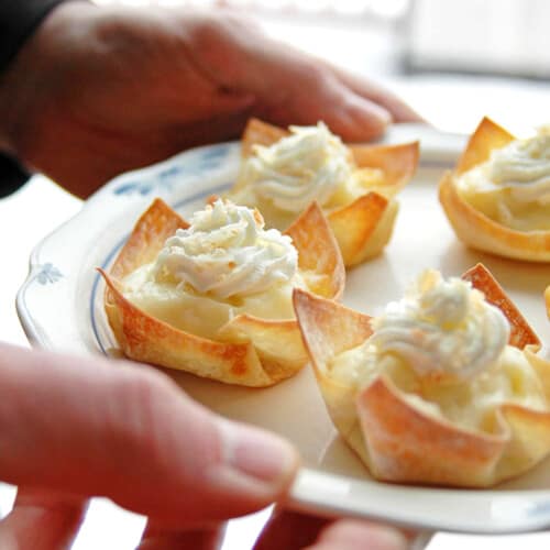 holding plate of coconut cream pie cups with whipped cream