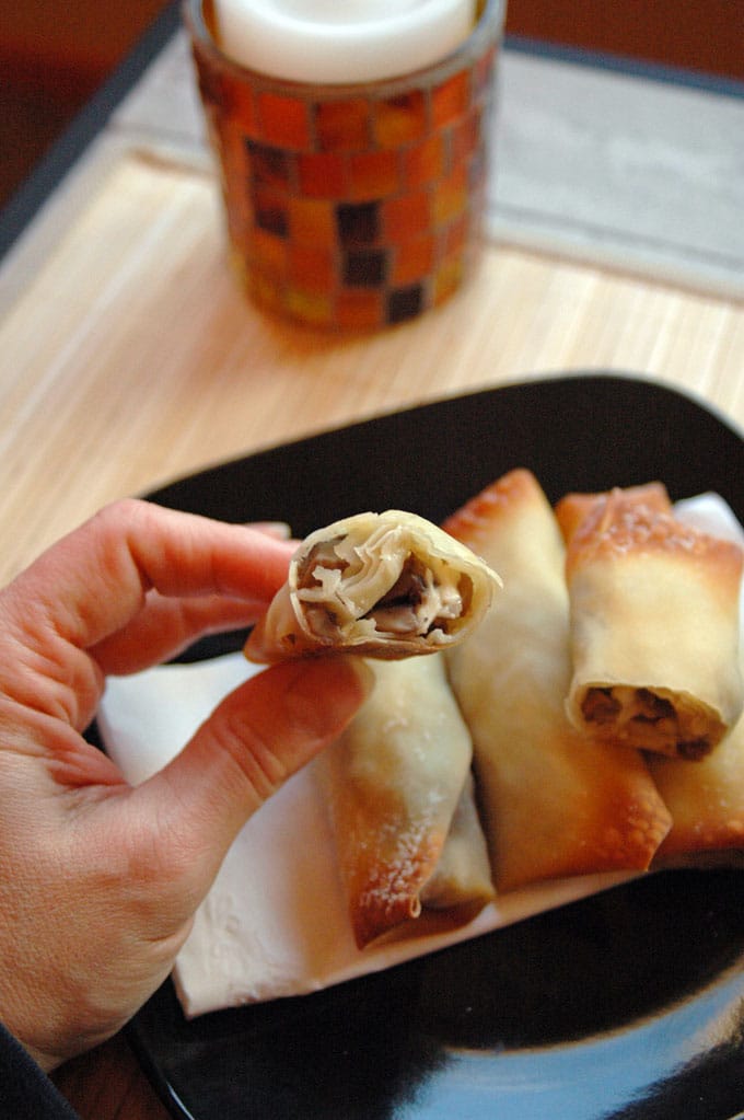 hand holding a Crispy Mushroom Onion Feta Roll with bite taken out 