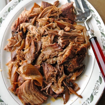 overhead shot of slow cooker Carolina pulled pork on a platter with a serving fork