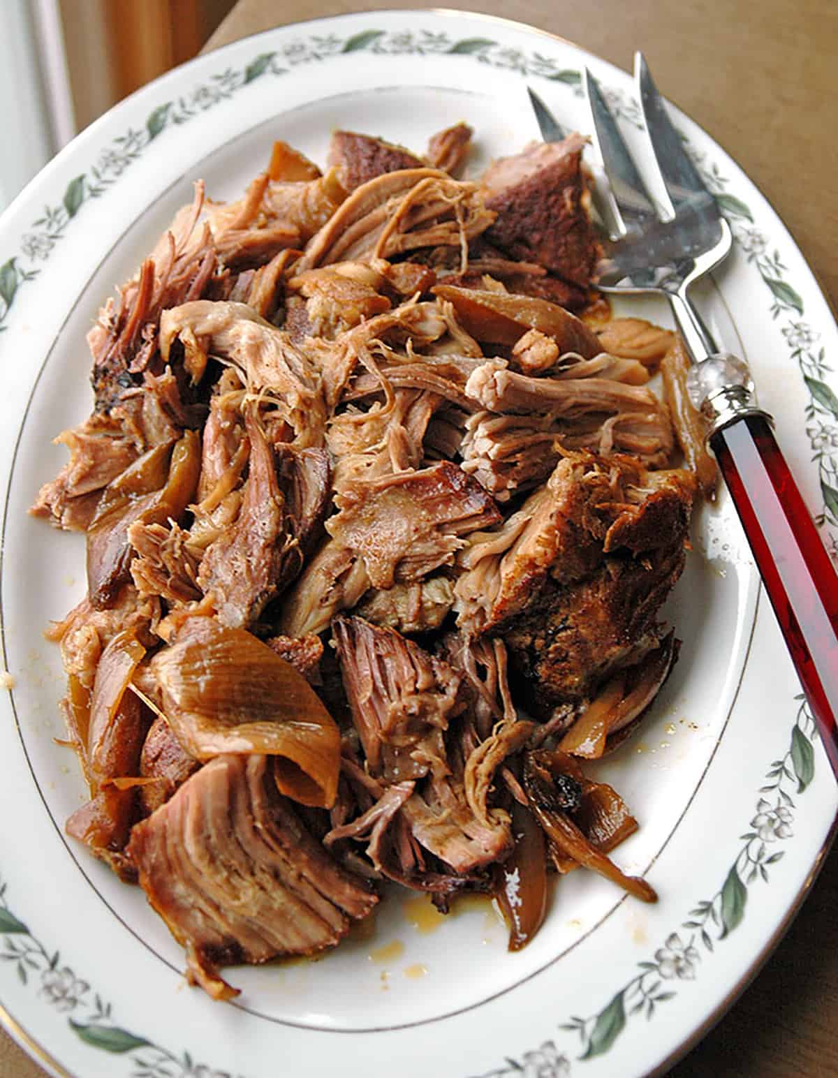 overhead shot of slow cooker Carolina pulled pork on a platter with a serving fork