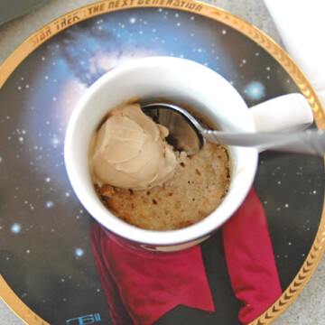 overhead view of White Chocolate Macadamia and Coconut Mug Cookie with spoon inside