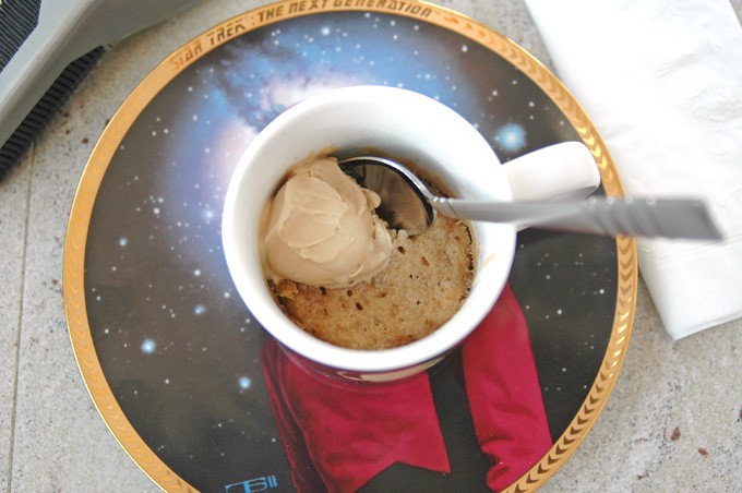 overhead view of White Chocolate Macadamia and Coconut Mug Cookie with spoon inside