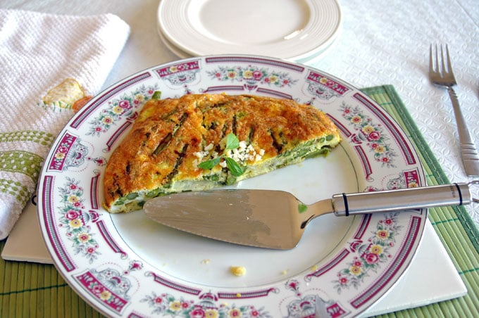 half of an Asparagus Frittata on a plate with pie server