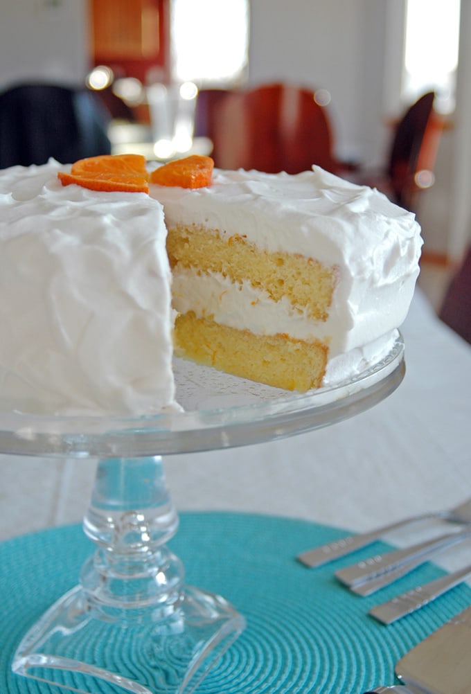 side view of a slice taken out of Orange Torte with Whipped Cream