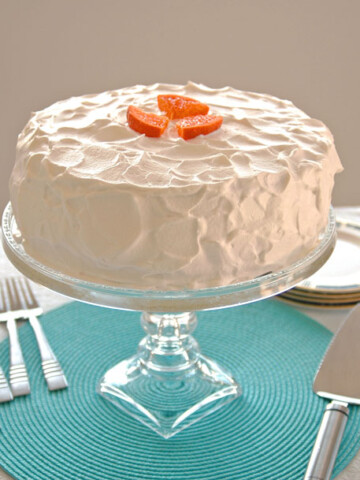Orange Torte with Whipped Cream on stand, pie server, forks