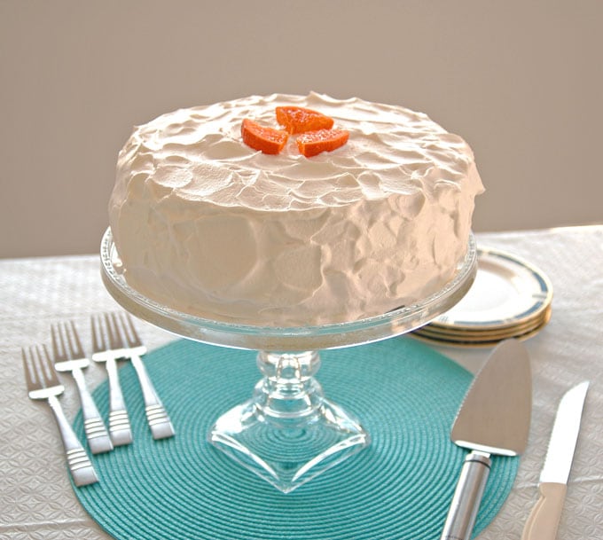 Orange Torte with Whipped Cream on stand, pie server, forks