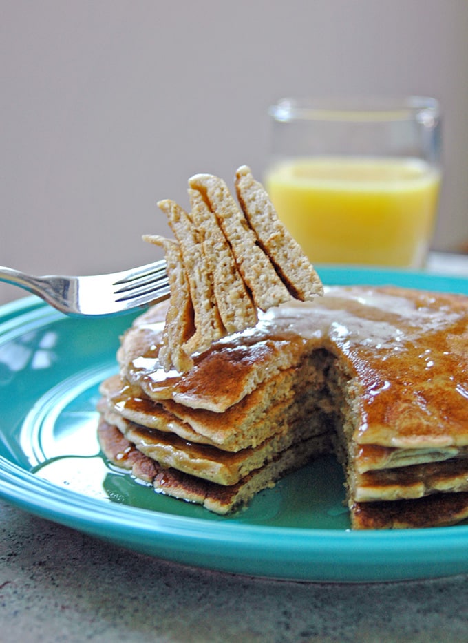 stack of Cinnamon Almond Multigrain Pancakes with a forkful being taken