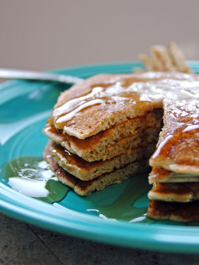 stack of Cinnamon Almond Multigrain Pancakes on a plate with a piece cut out