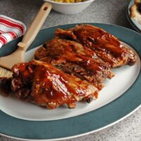 Slow Cooker BBQ Ribs on a plate with dressing brush