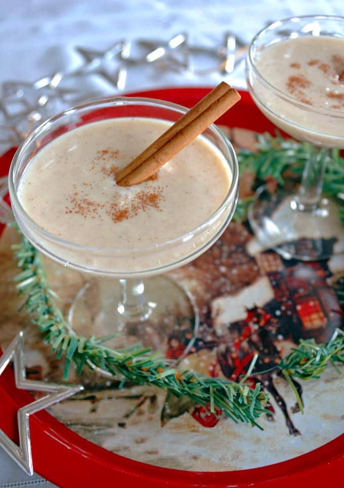 close-up overhead view of Coquito (Coconut-Rum Drink) in a martini glass with a cinnamon stick