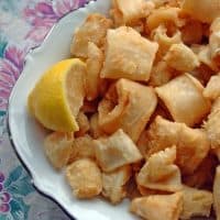 Neapolitan-Style Fried Calamari on a plate with a lemon wedge