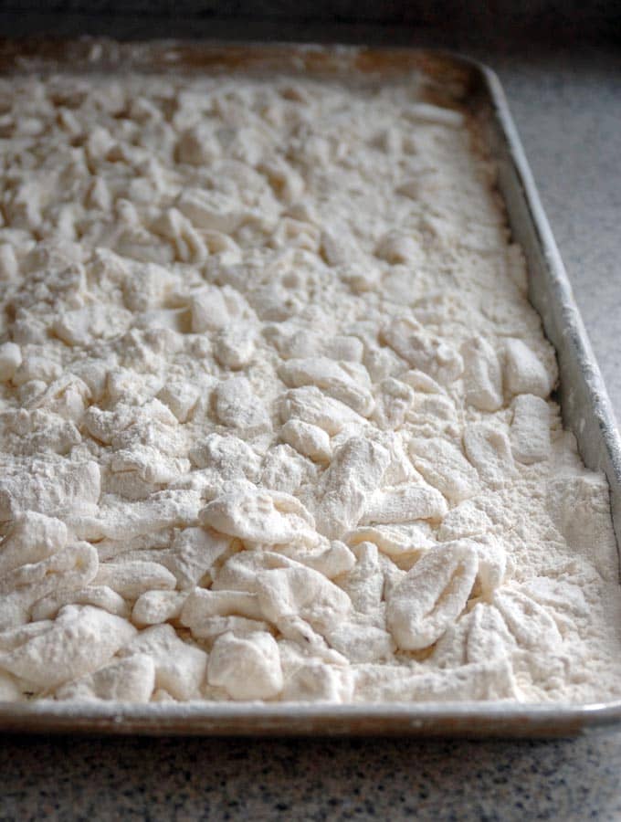 Calamari covered in flour on a sheet pan