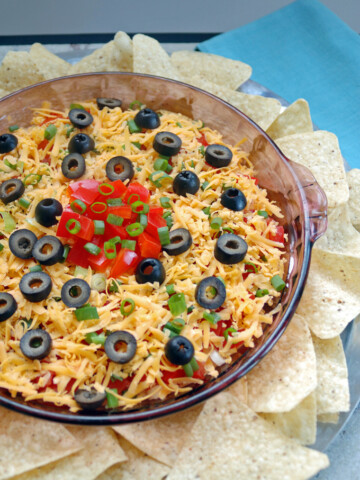 glass container of 7-Layer Taco Dip with tortilla chips