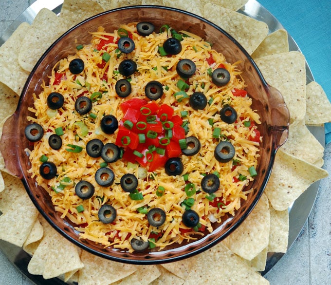 overhead view of 7-Layer Taco Dip in a dish surrounded by tortilla chips 