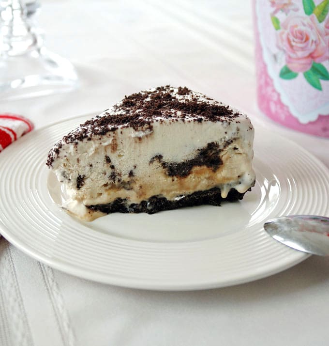 slice of vanilla-caramel ice cream cake with oreo crust on a plate