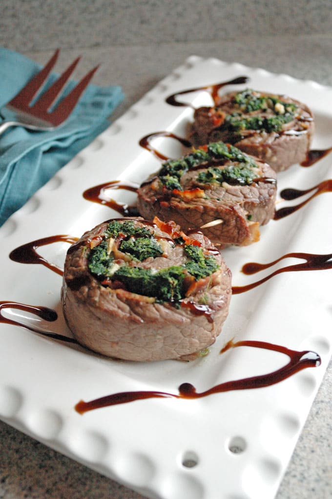 three pieces of Steak Pinwheels with Bacon, Spinach and Garlic on a platter