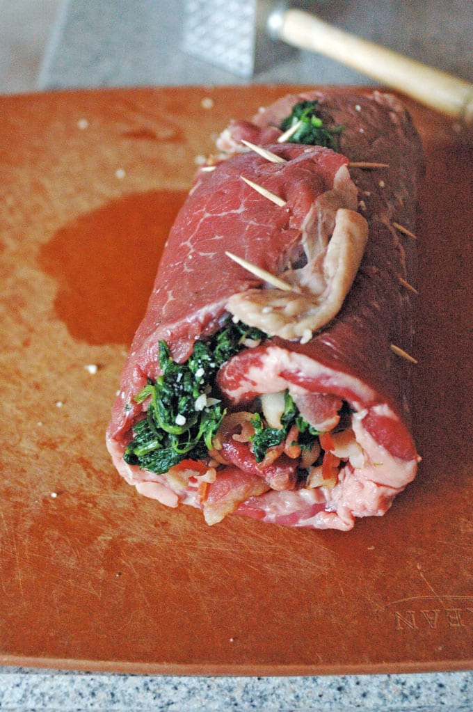 uncooked Steak Pinwheel with Bacon, Spinach and Garlic, tooth picks keeping them together