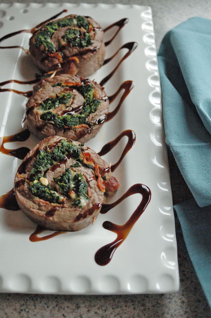 vertical photo of Steak Pinwheels with Bacon, Spinach and Garlic on a platter
