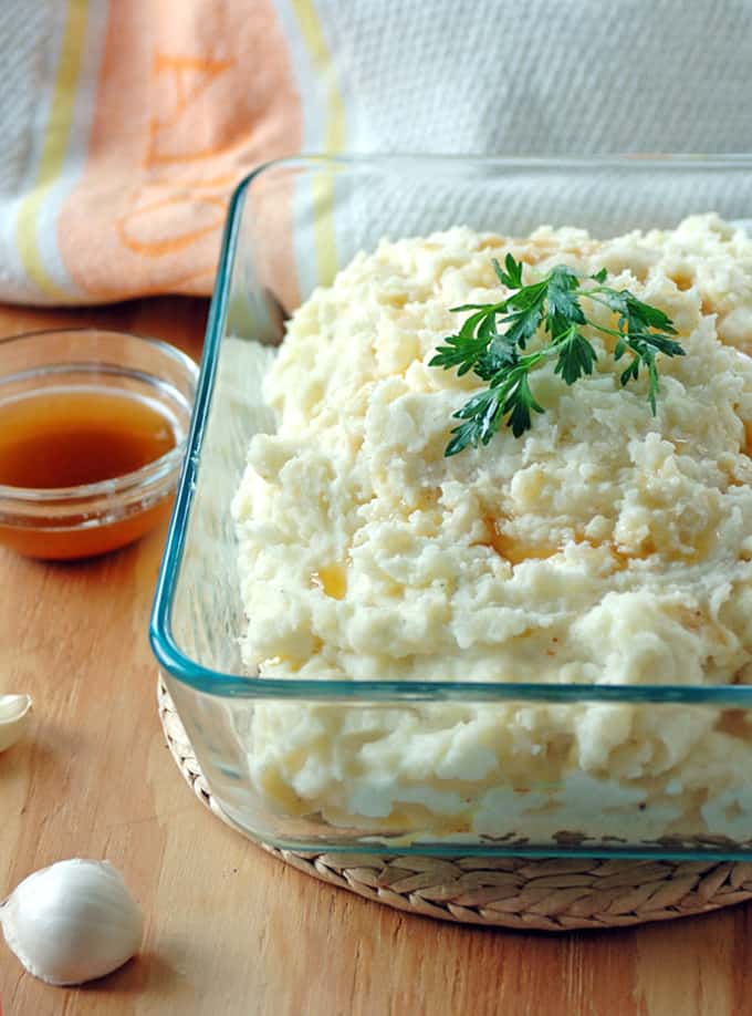 glass container with brown butter mashed potatoes and garnish