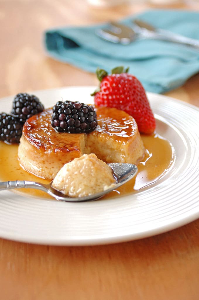 spoonful taken out of Low Fat Maple Flan with Berries on a plate