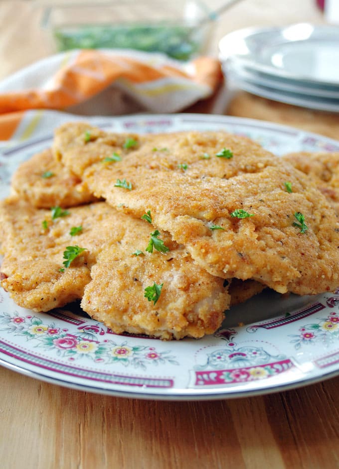 breaded italian chicken cutlets stacked on a plate