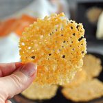 Parmesan crisp being held between thumb and finger