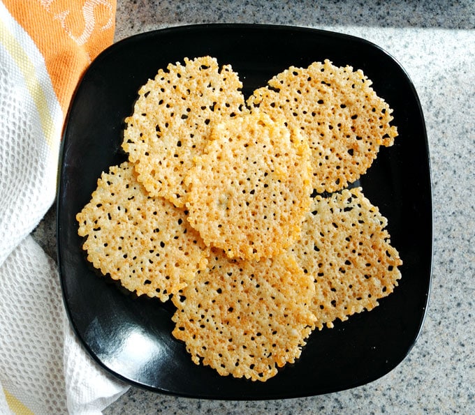 black plate with six Parmesan crisps