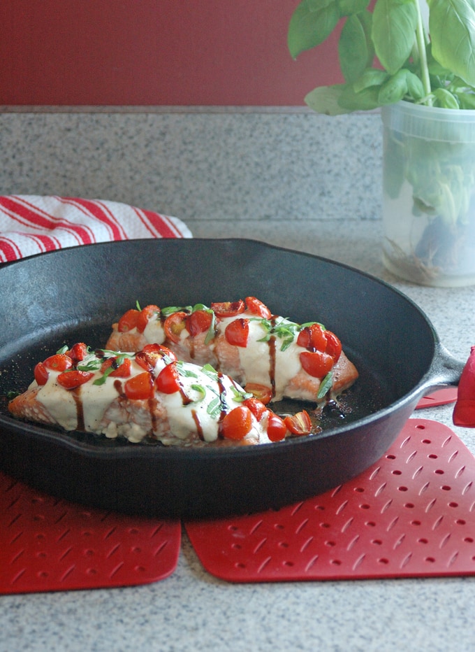 cast-iron skillet with 2 pieces of Salmon Caprese with Balsamic Glaze on a counter