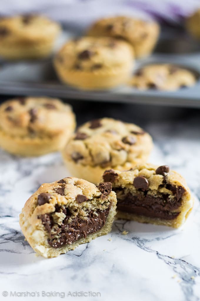 Nutella Stuffed Chocolate Chip Cookie Pie cut in half with full ones behind