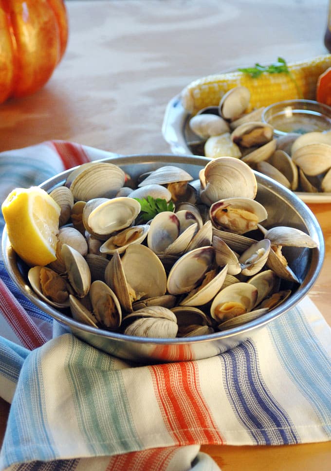 Side view of littleneck clams in a bowl with lemon