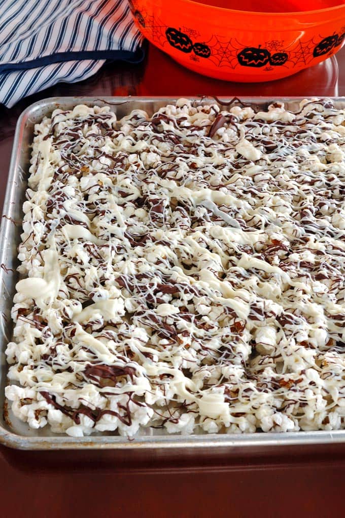 White and Dark Chocolate drizzled popcorn in a sheet tray