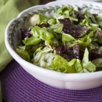 bowl of Italian green salad with homemade dressing and a napkin