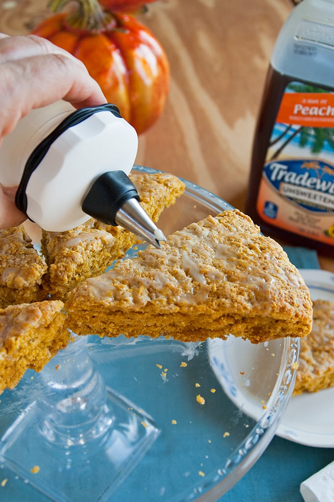 Peach tea glaze being drizzled on Peachy Pumpkin Scones