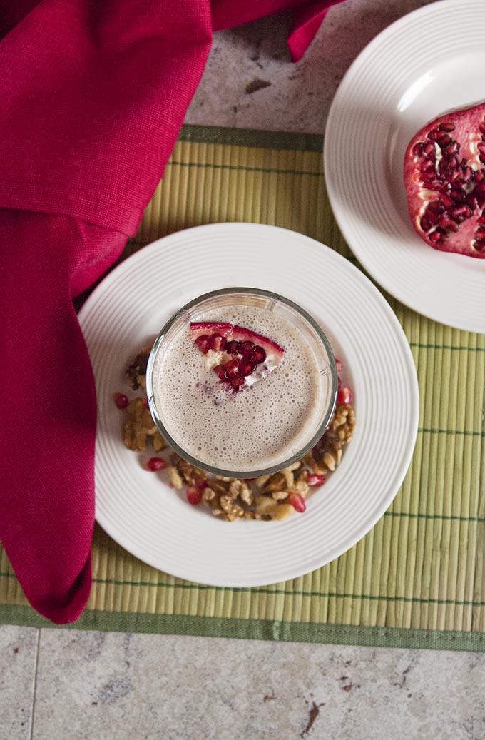 overhead view of glass of Pomegranate Smoothie with Banana and Walnuts