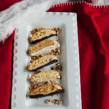 Chocolate-Dipped Hazelnut Biscotti on a platter, santa hat and mug