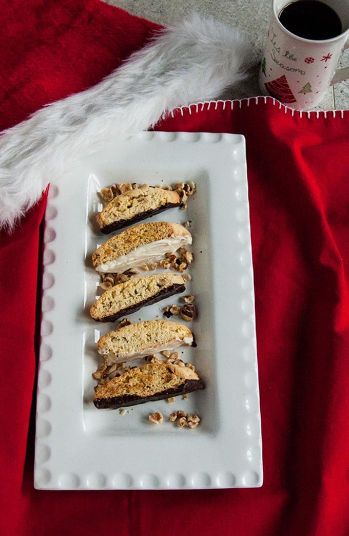 Chocolate-Dipped Hazelnut Biscotti on a platter, santa hat and mug