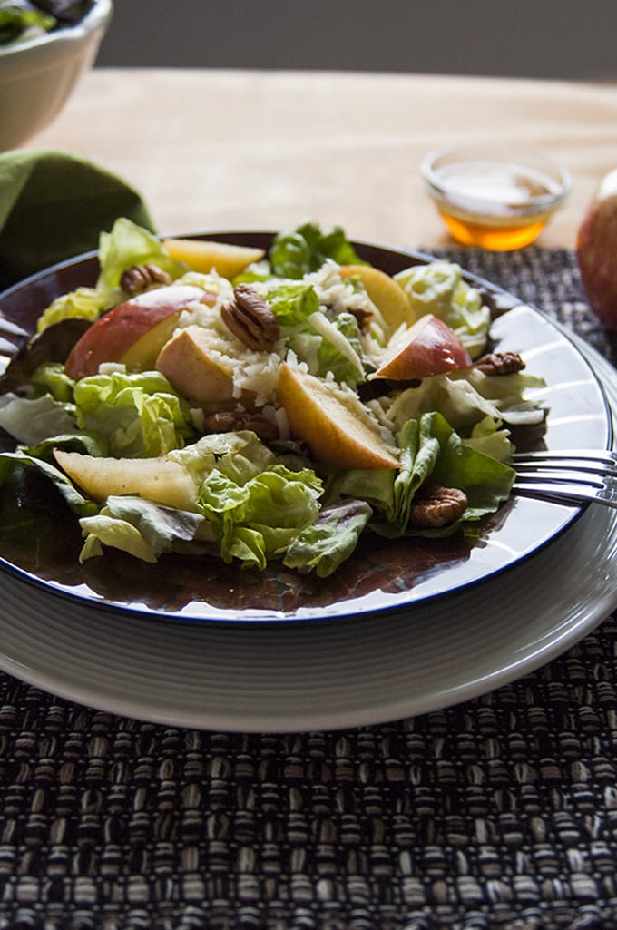 side view of a bowl of Apple Mozzarella Pecan Salad with Maple Vinaigrette and fork