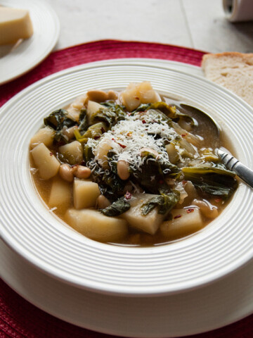 close-up of Tuscan white bean soup with escarole and potatoes in a bowl